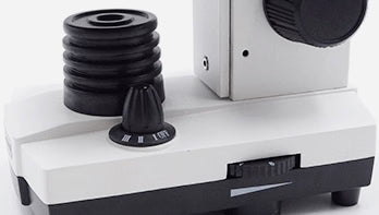 Coarse focus knob, condenser and brightness dial on the base of a student microscope