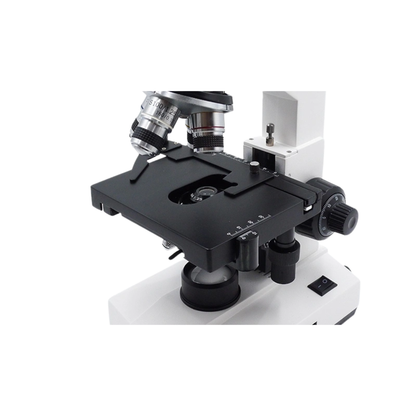 Close-up of a microscope mechanical stage with spring slide holder, vernier scale and coaxial knobs