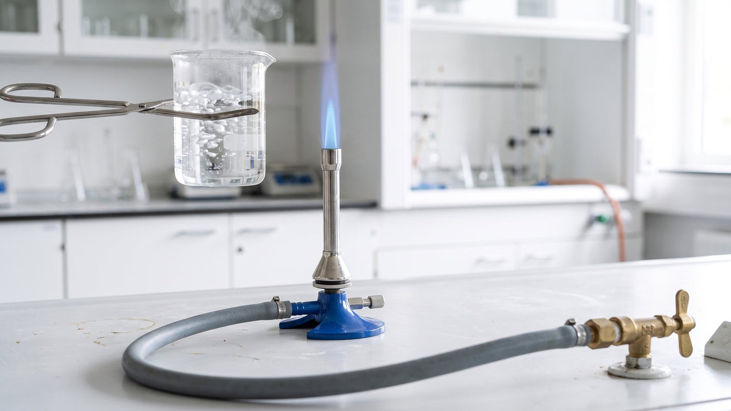 Bunsen burner flame heating a beaker of liquid, gas hose connected to a bench tap