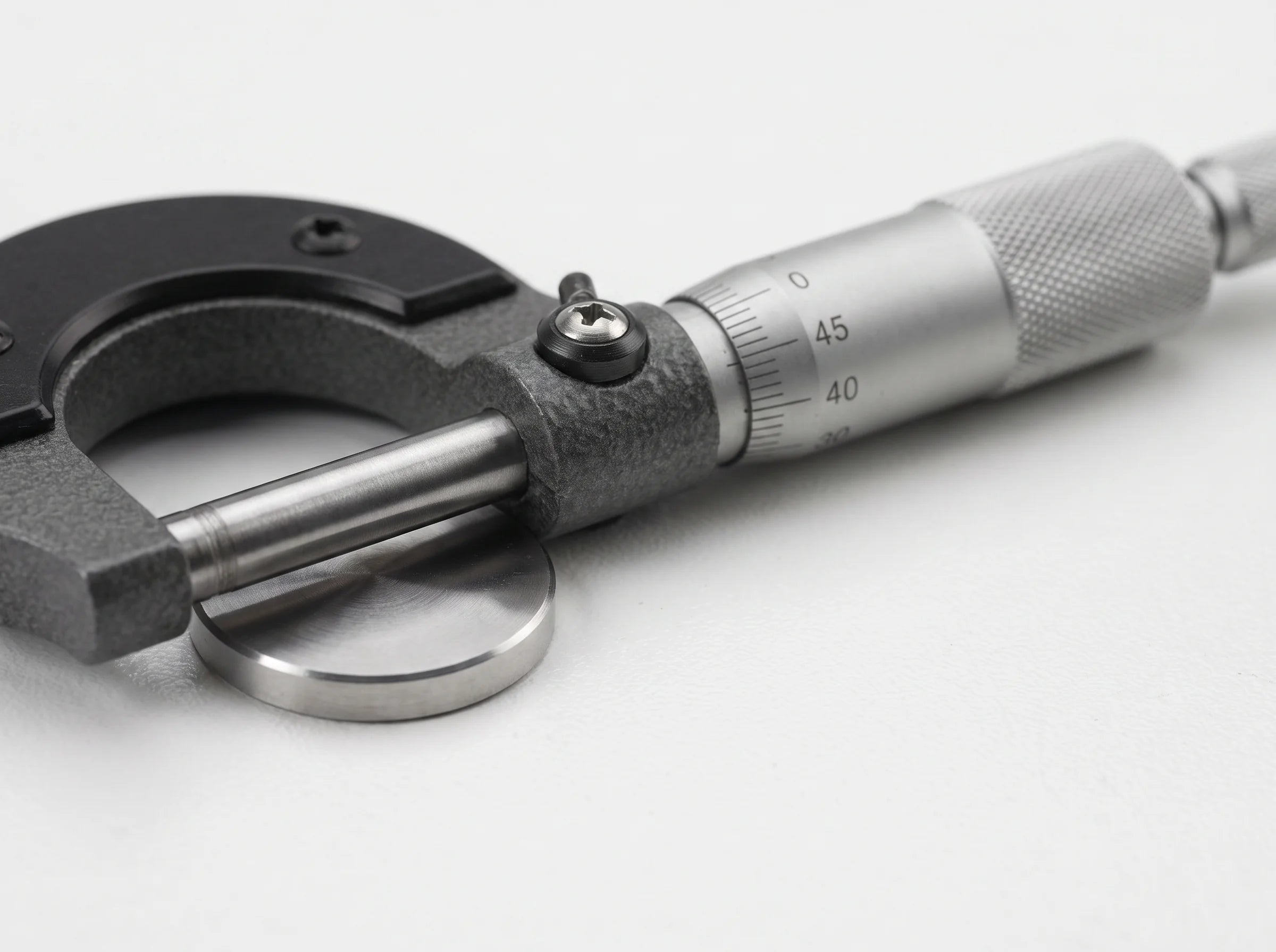 Micrometer screw gauge measuring a metal disc
