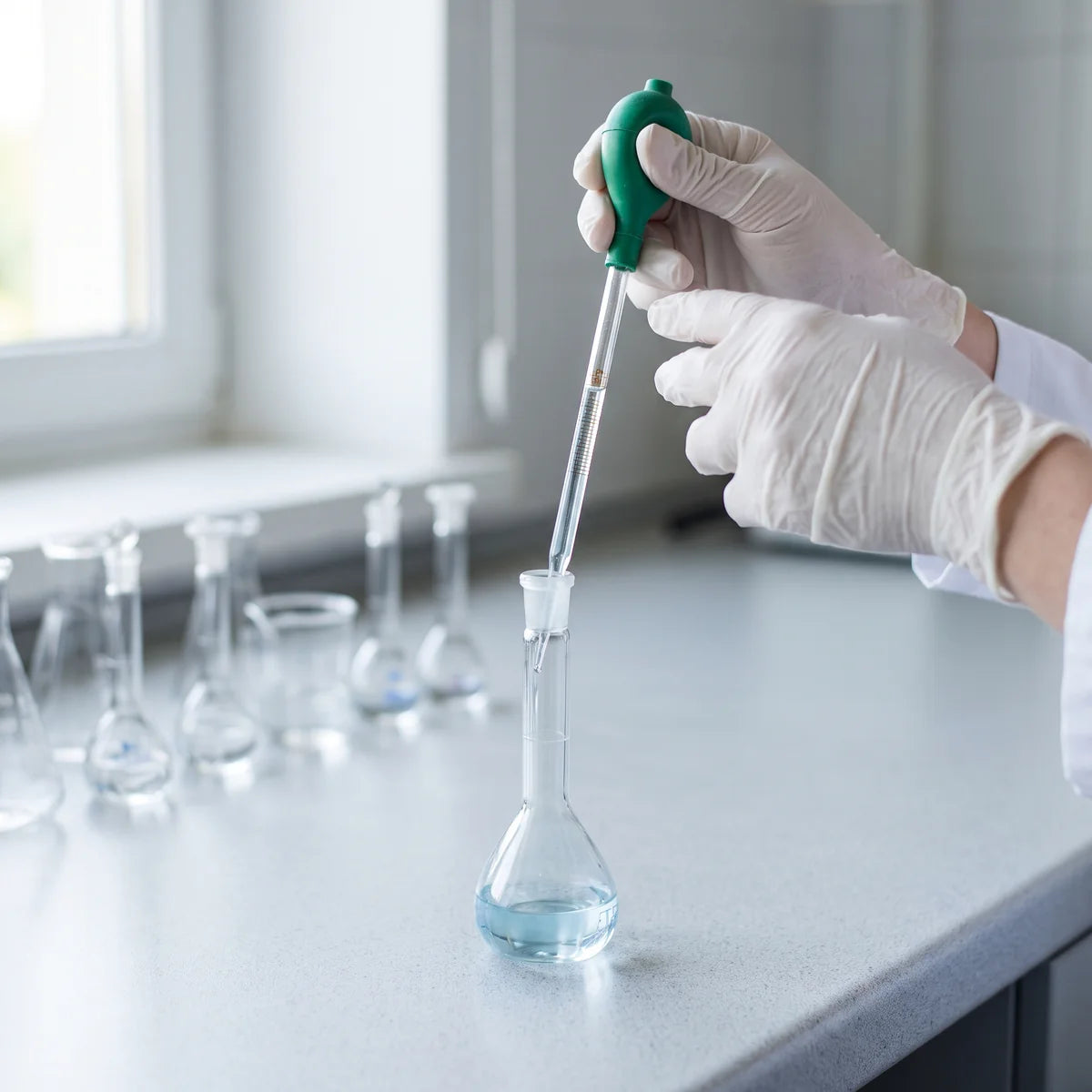 Pipetting stock solution into a glass volumetric flask to make an accurate dilution