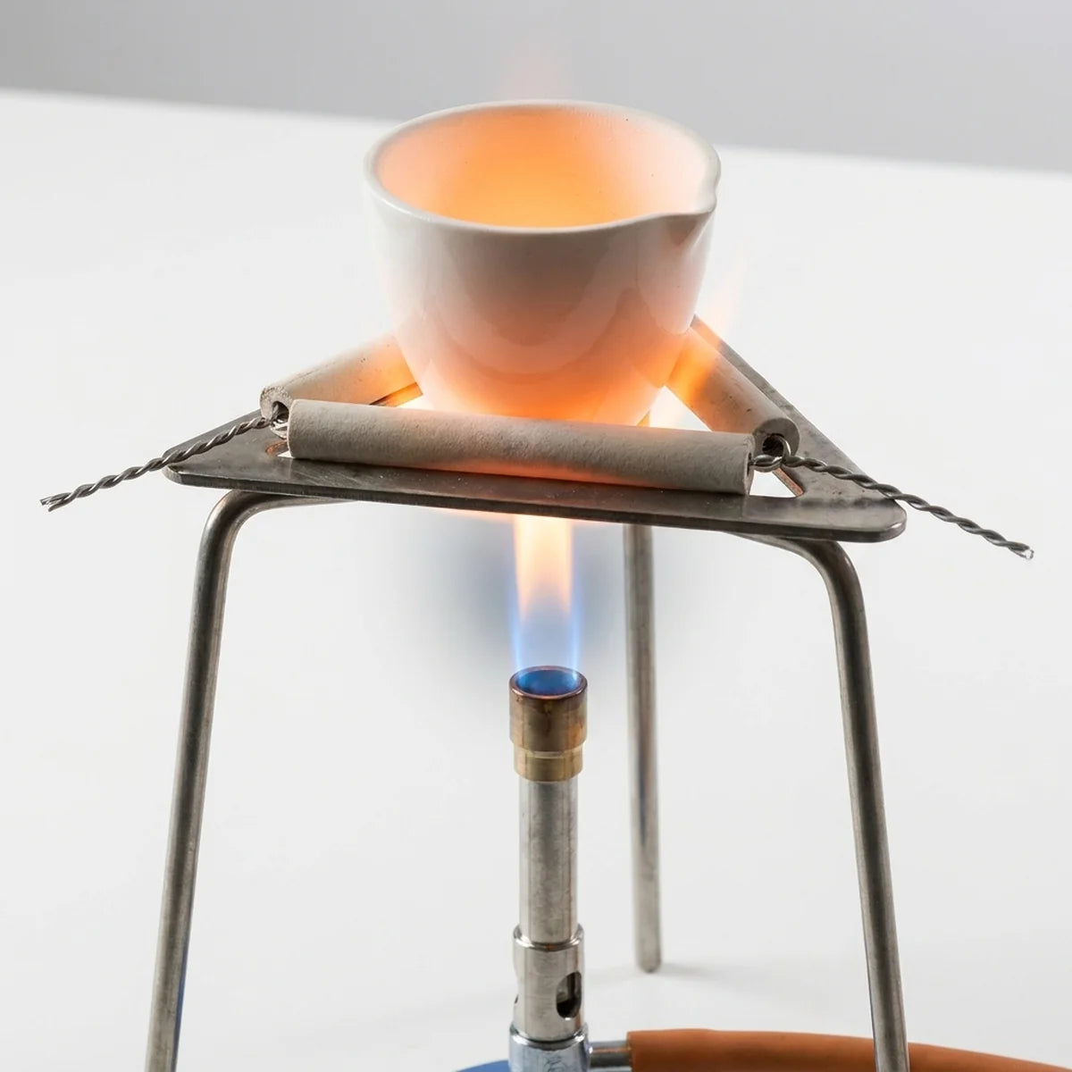 Crucible in clay triangle over Bunsen burner