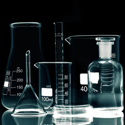 Set of laboratory glassware including beakers and flasks on a reflective surface with a black background