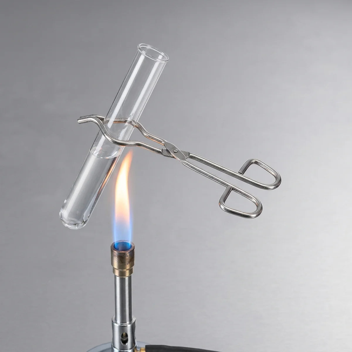 Test tube tongs holding tube over flame