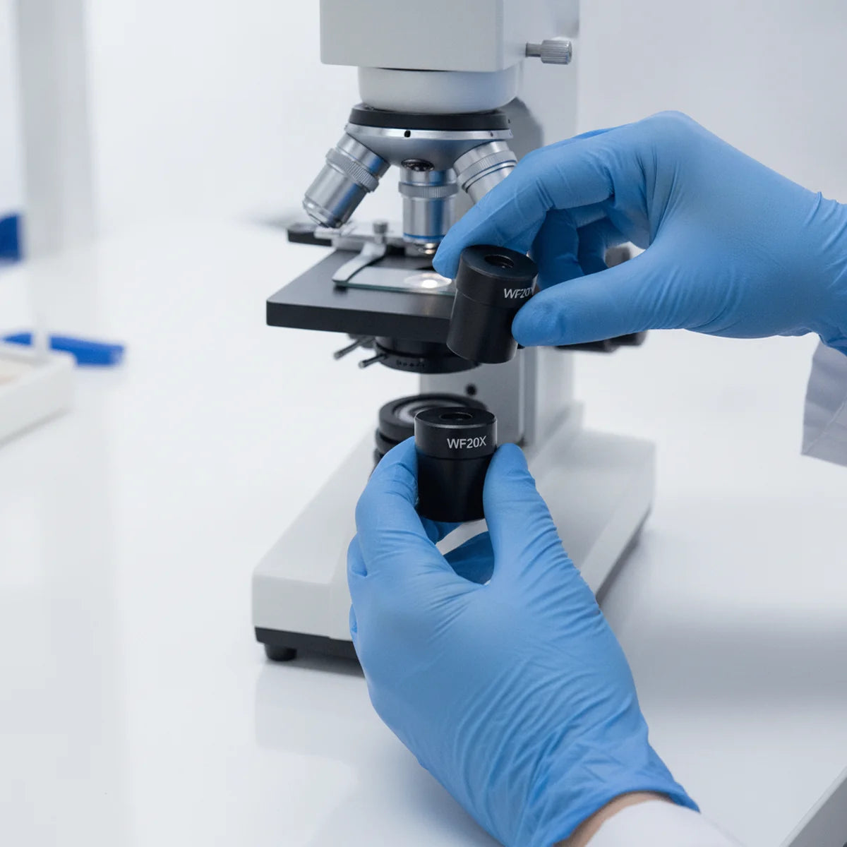Researcher swapping a microscope eyepiece lens