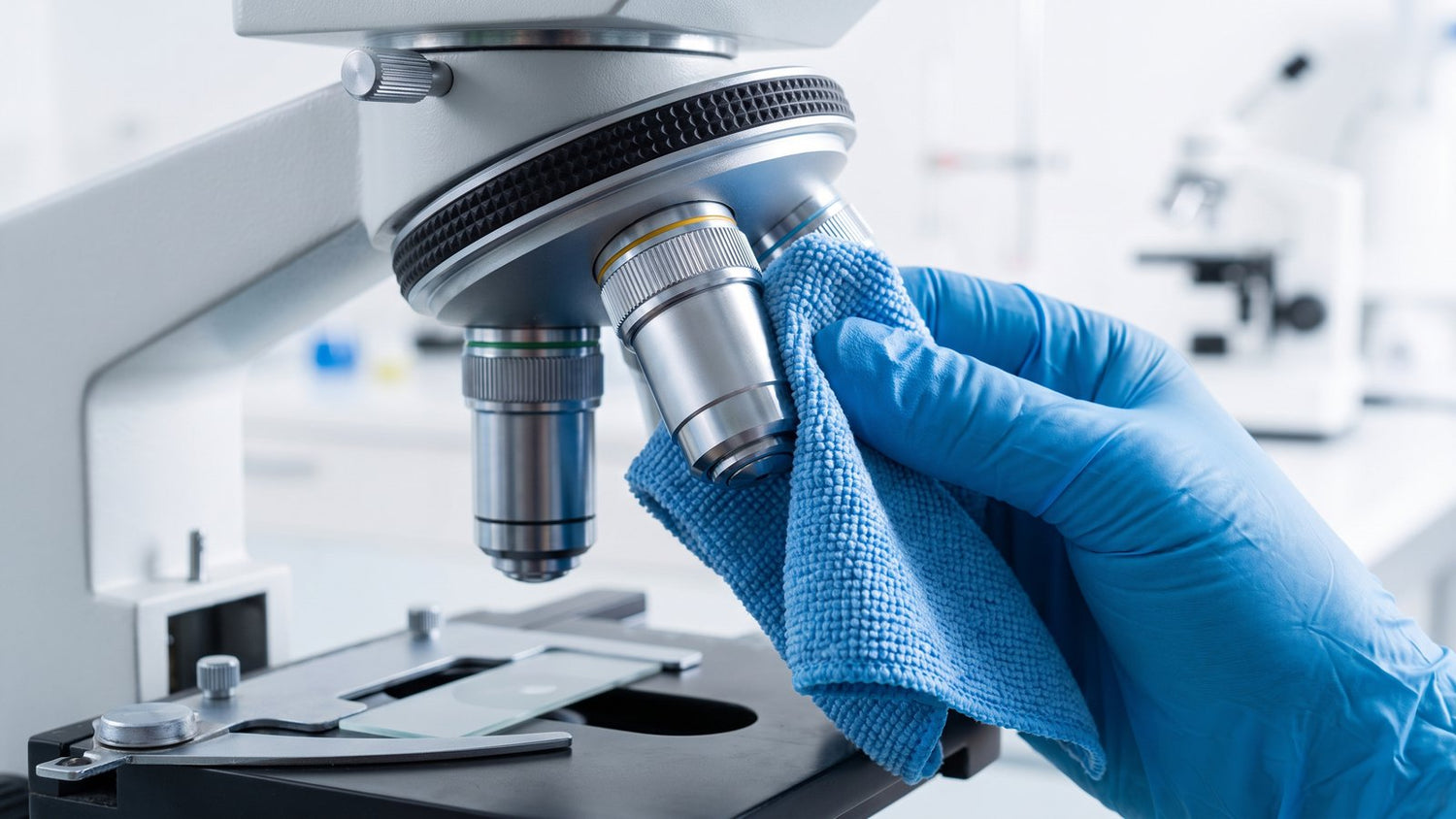 Wiping a microscope objective lens with a soft cleaning cloth