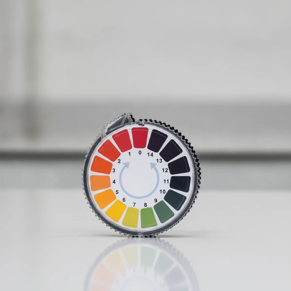 Roll dispenser of pH indicator paper with a built-in colour chart