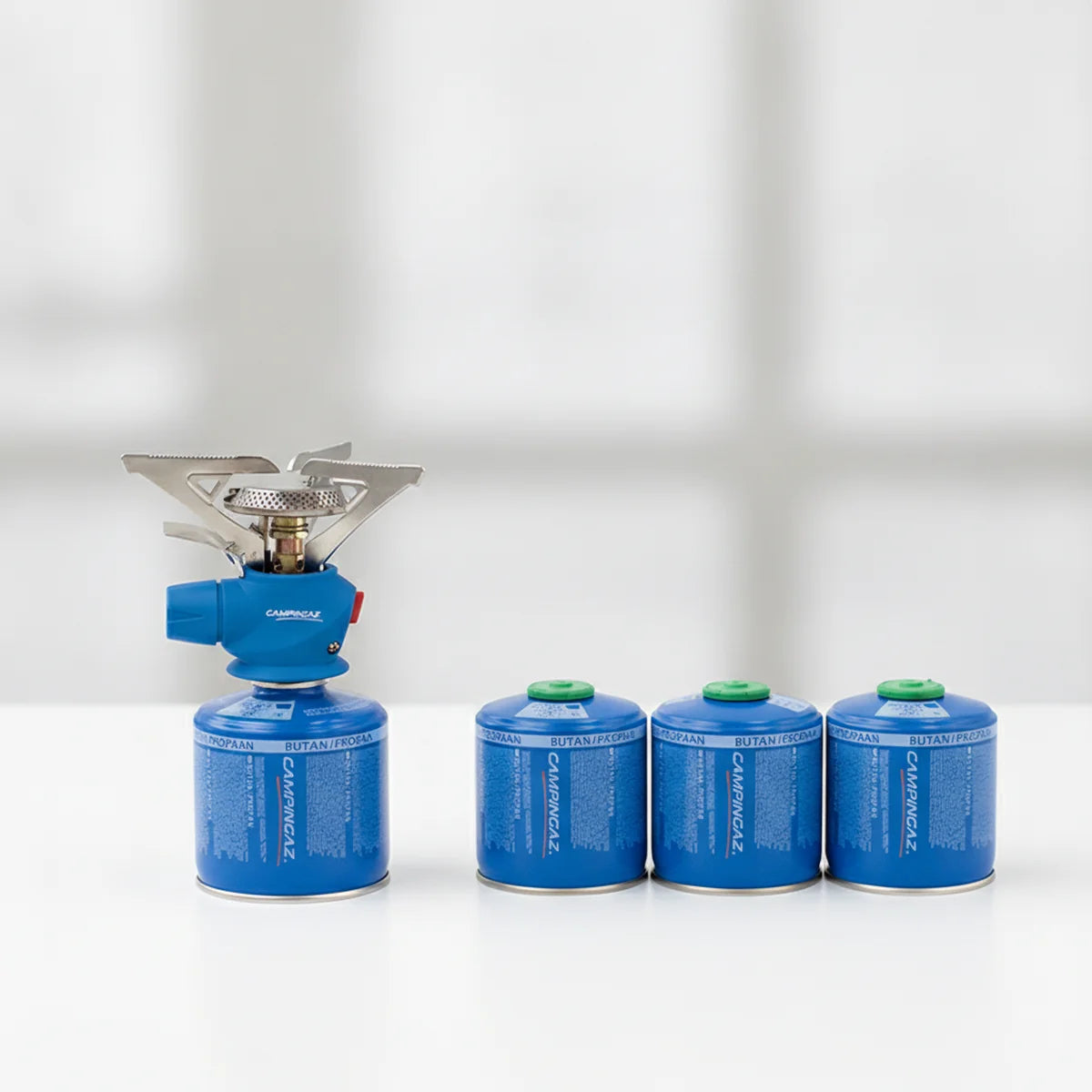 Portable stove burner head next to spare fuel cartridges