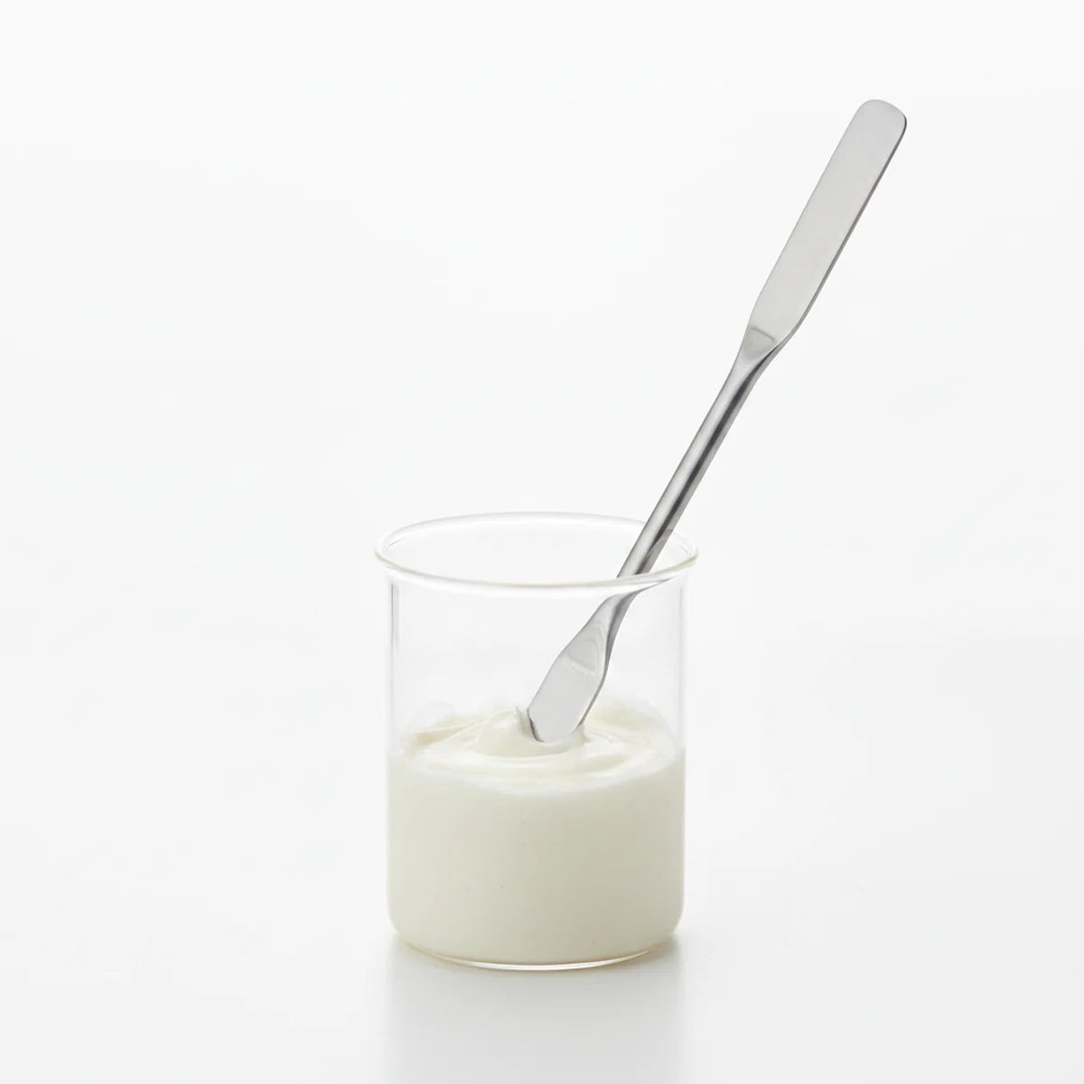 Spatula mixing compound in beaker