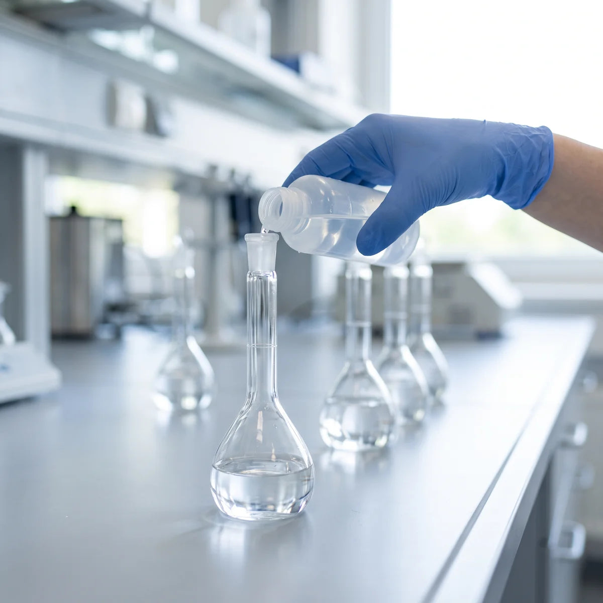 Pouring a water sample into a volumetric flask during sample preparation for analysis